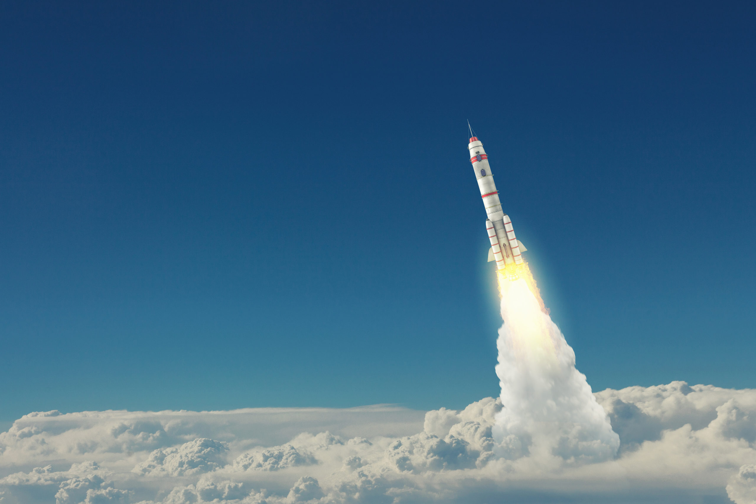 Rocket blasting off over clouds